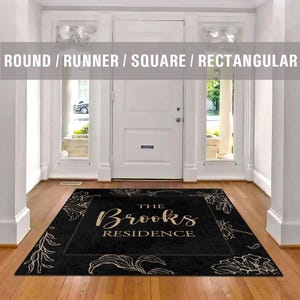 May include: Black doormat with a white floral border and the text "The Brooks Residence" in gold lettering.