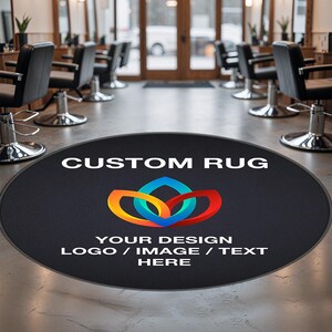 以下が含まれることがあります： 黒い丸い敷物に「CUSTOM RUG」と「YOUR DESIGN LOGO / IMAGE / TEXT HERE」という白い文字が書かれています。敷物の真ん中にはカラフルな抽象的なデザインが描かれています。