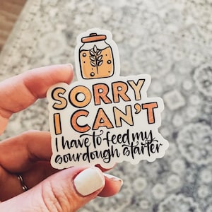 May include: A sticker with a cartoon illustration of a jar of sourdough starter and the text "Sorry I can't I have to feed my sourdough starter."