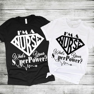 May include: Two t-shirts with a white graphic design. The design features a diamond shape with the word "NURSE" inside. The text "I'm a Nurse" is above the diamond. Below the diamond is the text "What's Your SuperPower?" with a stethoscope and a heart beat line.
