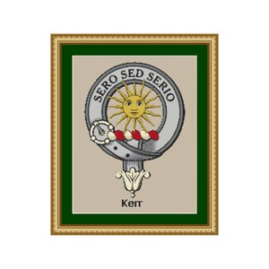 Peut inclure: Un motif de point de croix encadré représentant un blason avec un soleil et le texte "Sero Sed Serio" dans un cadre doré. Le texte "Kept" est sous le blason.