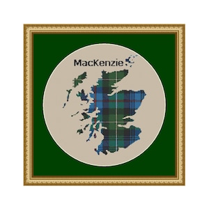 Puede incluir: Una obra de arte enmarcada que presenta un mapa de Escocia en el patrón tartán Mackenzie. El mapa está dentro de un círculo beige, con el nombre "Mackenzie" arriba. El marco es dorado y el fondo es verde oscuro.