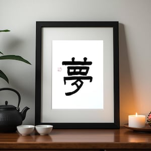Può includere: Stampa artistica con cornice nera con un carattere Kanji giapponese in inchiostro nero su carta bianca. L'opera d'arte è esposta su una superficie di legno, insieme a una teiera nera, due piccole ciotole bianche, una candela accesa e una composizione floreale.