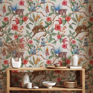 Pode incluir: Papel de parede com um vibrante design de selva, apresentando macacos, leopardos e flores coloridas. O design inclui tons de vermelho, rosa e azul, criando uma estética exótica. O papel de parede é exibido em uma parede acima de uma prateleira de madeira.