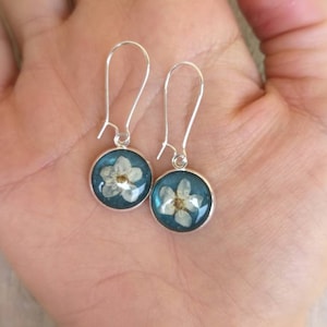 Petrol blue resin nuns with plum blossoms. Closed nun closure in silver color. H4xW1,6 cm
