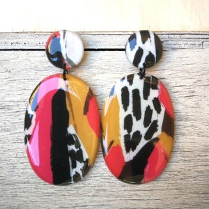 Oval earrings in pearly resin, black, coral and brown brushstroke motif. Length 6 cm, stainless steel butterfly clasp.