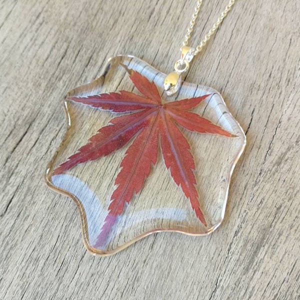Leaf-shaped pendant in transparent resin, with inserted maple leaf. H5.3xL5.5cm. Length and color of the chain of your choice.