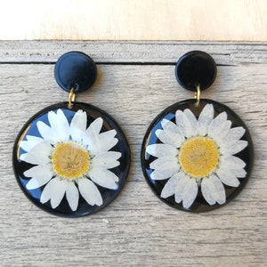 Black resin earrings with real daisies inserted. Stainless steel butterfly closure. H5.3xL3.8 cm