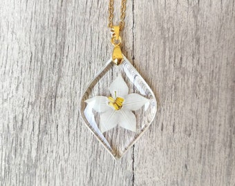 Small resin leaf pendant, with star jasmine flower inserted. Pendant L3xH4 cm. Thin gold-colored stainless steel chain.
