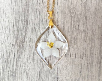 Small resin leaf pendant, with inserted star jasmine flower. Pendant L3xH4 cm. Thin gold-colored stainless steel chain.