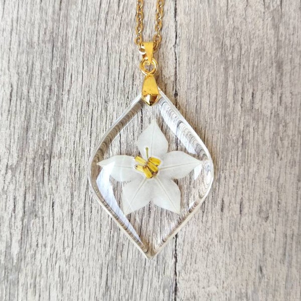 Small resin leaf pendant, with inserted star jasmine flower. Pendant L3xH4 cm. Thin gold-colored stainless steel chain.