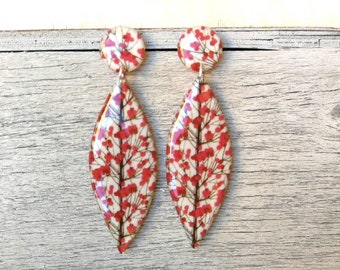 Leaf-shaped resin earrings, with red floral design. Anoding with stainless steel butterfly. Length 7.5 cm