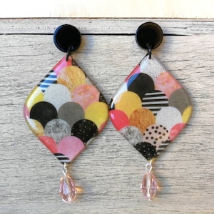 Orecchini a rombo in resina perlata, con motivo a squame di pesce multicolore e cristalli rosa. Chiusura a farfallina. H7,8xL3,8cm.