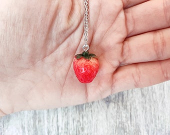 Collana in acciaio inox con ciondolo fragola in resina. Ciondolo 1,5x2 cm. Catena sottile con chiusura a moschettone.