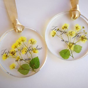Segnaposto per matrimonio personalizzati con monogramma. In resina, fiori veri inseriti. Diametro 6 cm. Quantità minima ordine 30 pezzi.