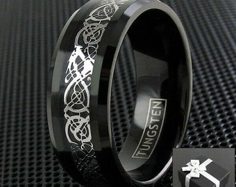 May include: A black tungsten ring with a silver Celtic knot design. The ring is engraved with the word "TUNGSTEN".