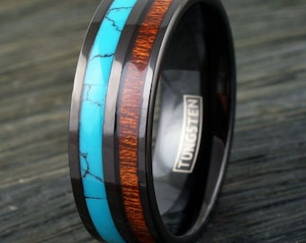 May include: Black tungsten ring with a turquoise and wood inlay. The ring is engraved with the word "TUNGSTEN".