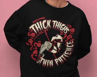 Może przedstawiać: Czarna bluza z czerwonym nadrukiem graficznym przedstawiającym kobietę z grubymi udami i tekstem "Thick Thighs Thin Patience" w kółku. W nadruku znajduje się również tekst "Murder Apparel".