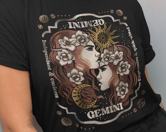 Puede incluir: Camiseta negra con una ilustración de estilo vintage del signo del zodíaco Géminis. La ilustración presenta dos mujeres con coronas de flores, un sol, una luna y el texto "GEMINI" y "Independiente & Curioso".