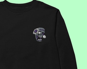 May include: Black sweatshirt featuring an embroidered skull with a flower on its head, in white and purple.