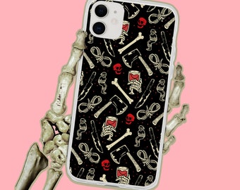 May include: A black phone case with a white border and a repeating pattern of red wine glasses, axes, skulls, and rope. The phone case is designed for an iPhone with a camera cutout.