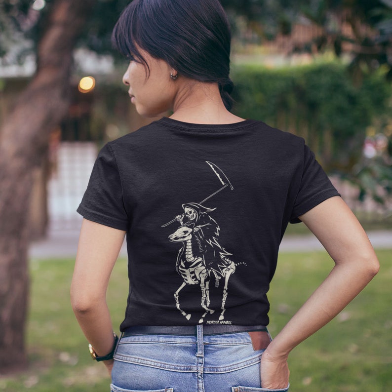 May include: Black t-shirt featuring a white graphic of a skeleton riding a skeletal horse and holding a scythe. The text "PREMIER APPAREL" is printed at the bottom of the graphic.