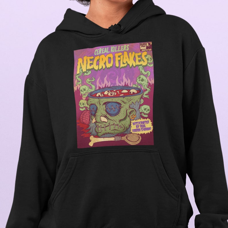 May include: Black hoodie with a graphic print of a cereal box with a zombie head in a bowl. The box says "Cereal Killers Necro Flakes" and "Witchcrafted by Real Voodoo Sorcery".