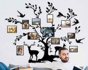 May include: A black silhouette of a tree with branches extending out, holding framed photos of families and couples. Two deer silhouettes are at the base of the tree. The tree is mounted on a white wall.