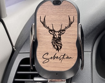 Peut inclure: Un chargeur de téléphone de voiture noir et bois avec une silhouette de cerf et le nom "Sebastian" gravé dessus. Le chargeur est monté dans une bouche d'aération de voiture.