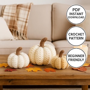 May include: Three cream and yellow crocheted pumpkins with brown stems are displayed on a wooden table with autumn leaves. The image includes text that says "PDF Instant Download", "Crochet Pattern", and "Beginner Friendly".
