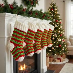 Könnte beinhalten: Fünf handgefertigte Weihnachtsstrümpfe hängen über einem Kamin. Die Strümpfe sind rot und grün mit einem Streifenmuster und weißen Bündchen. Rechts steht ein Weihnachtsbaum mit Lichtern und Ornamenten, und eine Girlande mit Beeren und Tannenzapfen schmückt den Kaminsims.
