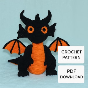 Pode incluir: Um brinquedo de dragão de crochê em preto e laranja. O dragão tem olhos grandes laranja, chifres e asas. O corpo é laranja, e as asas têm um interior laranja. O texto "CROCHET PATTERN" e "PDF DOWNLOAD" estão na imagem.