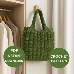 Peut inclure: Un sac fourre-tout en crochet vert avec un motif texturé en forme de bulles. Le sac a deux anses et est suspendu à une cheville en bois. L'image comprend également le texte "PDF TÉLÉCHARGEMENT INSTANTANÉ" et "PATRON DE CROCHET".