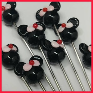 May include: A set of six black glass mouse-shaped beads with pink and red accents, attached to silver metal skewers.