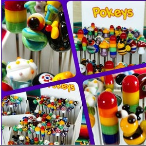 May include: A display of colorful glass Pokkeys, each with a unique design. The Pokkeys are on metal pins and are arranged in a grid pattern. The Pokkeys are made of glass and have a variety of colors and designs, including rainbow, bee, mushroom, and cupcake.