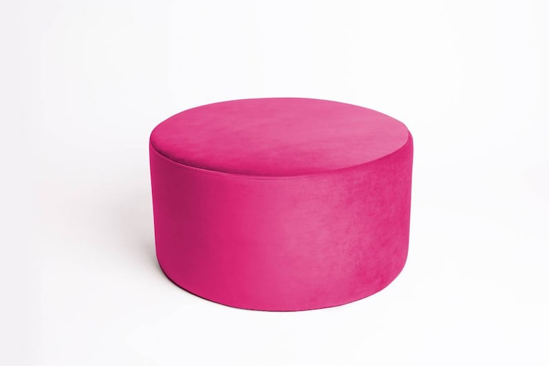 May include: A round, pink velvet ottoman.