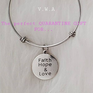 May include: Silver-toned adjustable bracelet with a round charm. The charm is engraved with the words "Faith Hope & Love". The bracelet also has the text "V.W.A" and "The perfect QUARANTINE GIFT FOR..." in the image.