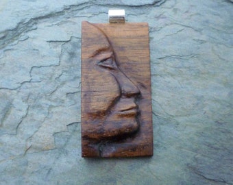 Carved face pendant, walnut and silver