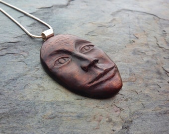Carved face pendant, walnut and silver
