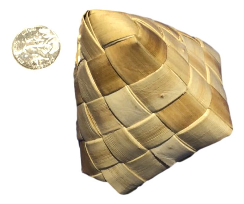 May include: A woven basket with a square shape, crafted from light and dark brown natural fibers. The basket has a checkered pattern. A silver coin is next to the basket.