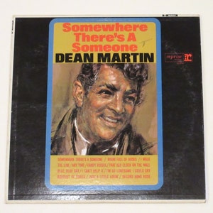 May include: A vintage vinyl record album cover featuring Dean Martin. The cover is blue and yellow with a portrait of Dean Martin smiling. The album title is "Somewhere There's A Someone".
