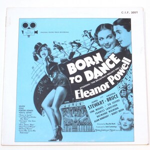May include: A vintage record album cover featuring a black and white image of Eleanor Powell, a dancer, in a black and white dress. The album cover is for the movie "Born to Dance" and features the text "The Broadway Melody Girl".