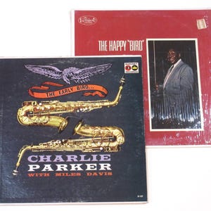 May include: A vintage vinyl record album cover featuring Charlie Parker with Miles Davis. The cover art features a black and white image of two saxophones and a bird with wings spread. The album title is "The Early Bird..." and the record label is "Baronet Records".