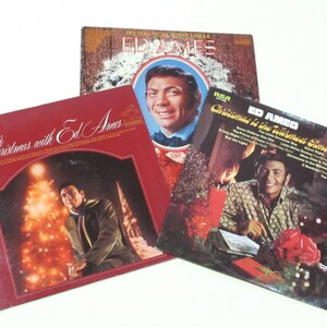May include: Three vintage vinyl records by Ed Ames featuring Christmas music. The covers feature a red and white color scheme with images of Ed Ames and holiday decorations.