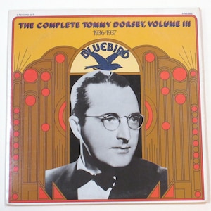 May include: A vintage vinyl record album cover for "The Complete Tommy Dorsey, Volume III 1936-1937." The cover features a black and white portrait of a man wearing glasses and a bow tie, with the Bluebird logo and text in a retro design.