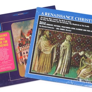 May include: Two vinyl record albums with Renaissance Christmas music. The album covers feature artwork depicting scenes from the Christmas story. The album on the left has a pink label with the text "Renaissance Choral Music for Christmas". The album on the right has a blue label with the text "A Renaissance Christmas".