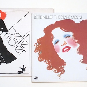 May include: Two vinyl record covers featuring Bette Midler. The first cover is black and white with a stylized illustration of Bette Midler in a dress. The second cover is in color and features a close-up of Bette Midler's face with red hair.