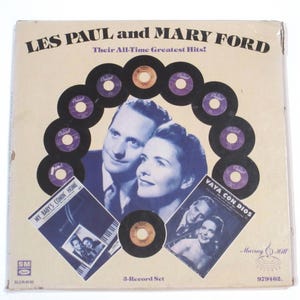 May include: A vintage record album cover featuring a photo of Les Paul and Mary Ford. The cover is cream-colored with a brown border and features a circle of black vinyl records with gold labels. The text on the cover reads "LES PAUL and MARY FORD Their All-Time Greatest Hits!" and "3-Record Set".