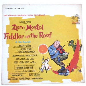 May include: A yellow record album cover with a drawing of a man playing a fiddle. The album is titled "Fiddler on the Roof" and features the name "Zero Mostel" in large letters. The album is a Broadway cast recording of the musical.