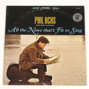 May include: A vintage vinyl record album cover featuring Phil Ochs, a singer-songwriter, sitting on a guitar case and reading a newspaper. The album title is "All the News that's Fit to Sing" with the text "Danny Kalb, second guitar" below the title.